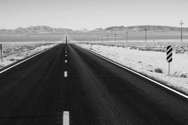 grayscale photo of road on desert